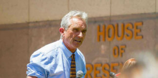 Man speaking into microphone outside House of Representatives
