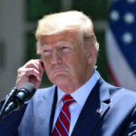 Trump’s Ukraine Plan STUNS—America’s Role Flipped Man in a suit adjusting an earpiece.