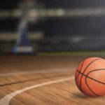 A basketball resting on a wooden court