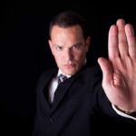 Referee Abuse Shocks Fans — Match Halted! Businessman in a suit making a stop gesture with his hand