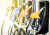 Massive Gas Price Shift – Holiday Relief! Colorful gas pump nozzles at a station.