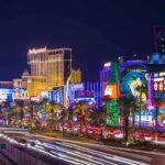 Vegas Strip’s Unprecedented 2025 Visitor Collapse Vibrant view of the Las Vegas Strip at night with neon lights and traffic