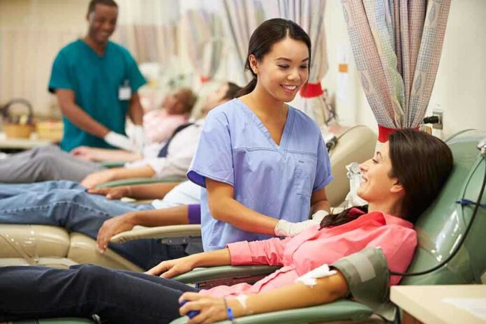 A nurse smiling at a female donor during a blood donation session