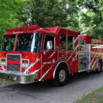 Deadly Blaze Exposes Shocking Safety Meltdown A red fire truck parked in a green park