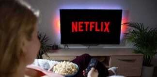 Person watching Netflix on a TV while holding a bowl of popcorn