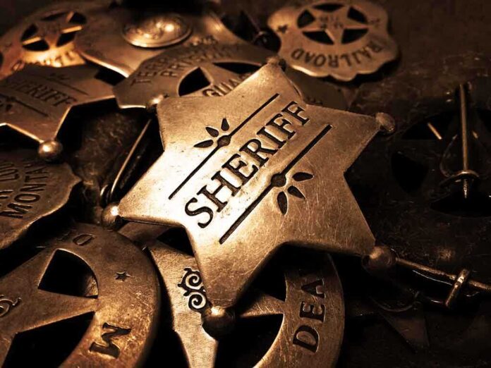 shutterstock_212353798.jpg A collection of vintage sheriff badges arranged on a dark surface
