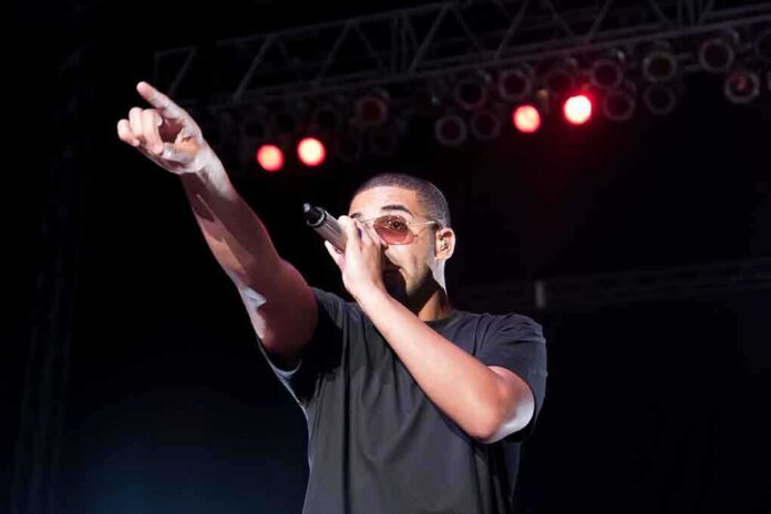 Musician performing on stage with a microphone and pointing to the audience