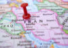 Red pushpin marking Iran on a map.