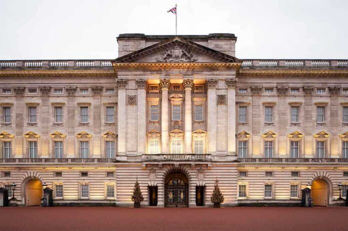 shutterstock_155262830 Front view of Buckingham Palace with illuminated facade and British flag