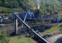 Industrial coal processing plant with conveyor belts and smokestack.