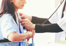 Doctor examining patient with stethoscope in hospital