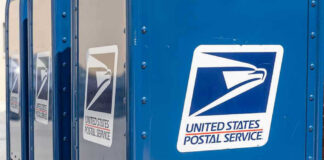 Blue USPS mail collection boxes in a row.