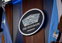 The Pentagon emblem between two flags.