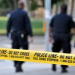 Freed Felon Allegedly Attacks At Target Police officers walking past caution tape at a crime scene