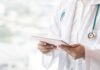 Doctor with stethoscope using a tablet