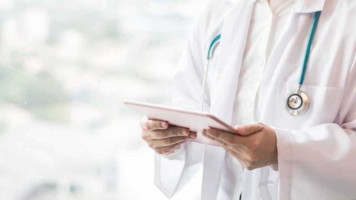 Doctor with stethoscope using a tablet