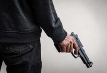 person holding a handgun at their side