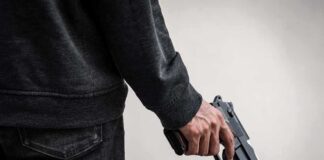 person holding a handgun at their side