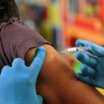 Healthcare worker administering vaccine in upper arm