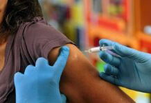 Healthcare worker administering vaccine in upper arm