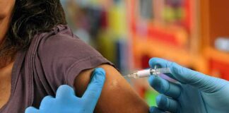 Healthcare worker administering vaccine in upper arm