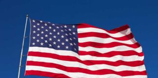 Waving American flag against a clear blue sky