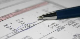 Close-up of a financial document with highlighted numbers and a pen