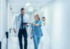Doctors walking in a hospital corridor reviewing a tablet