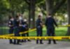 crime scene tape with police officers in a park