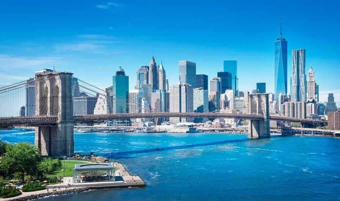 Brooklyn Bridge spanning blue river with modern city skyline