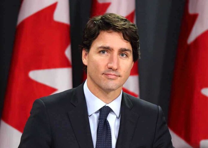 man in suit at podium with Canadian flags