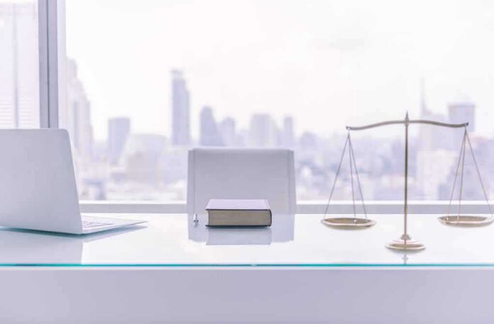 law office desk with laptop book and scales of justice