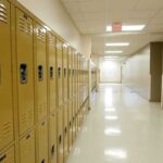Row of yellow school lockers in an empty hallway