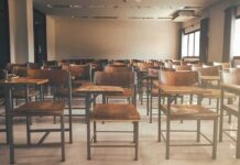 Empty classroom with rows of wooden desks and chairs