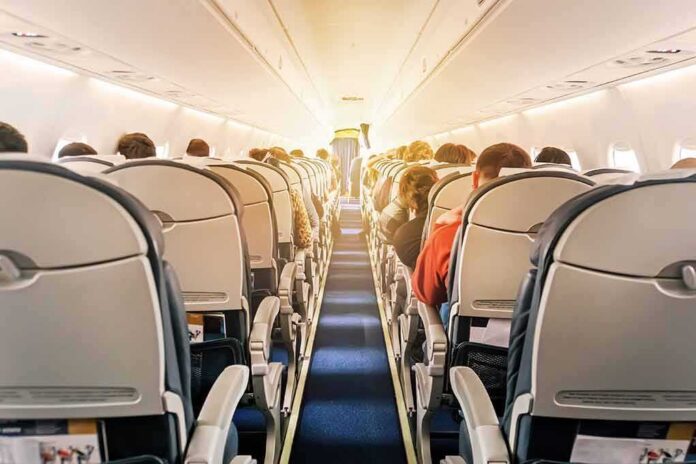 airplane cabin with passengers seated in economy class