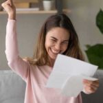woman celebrating while reading a letter