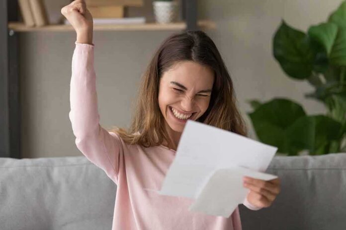 woman celebrating while reading a letter